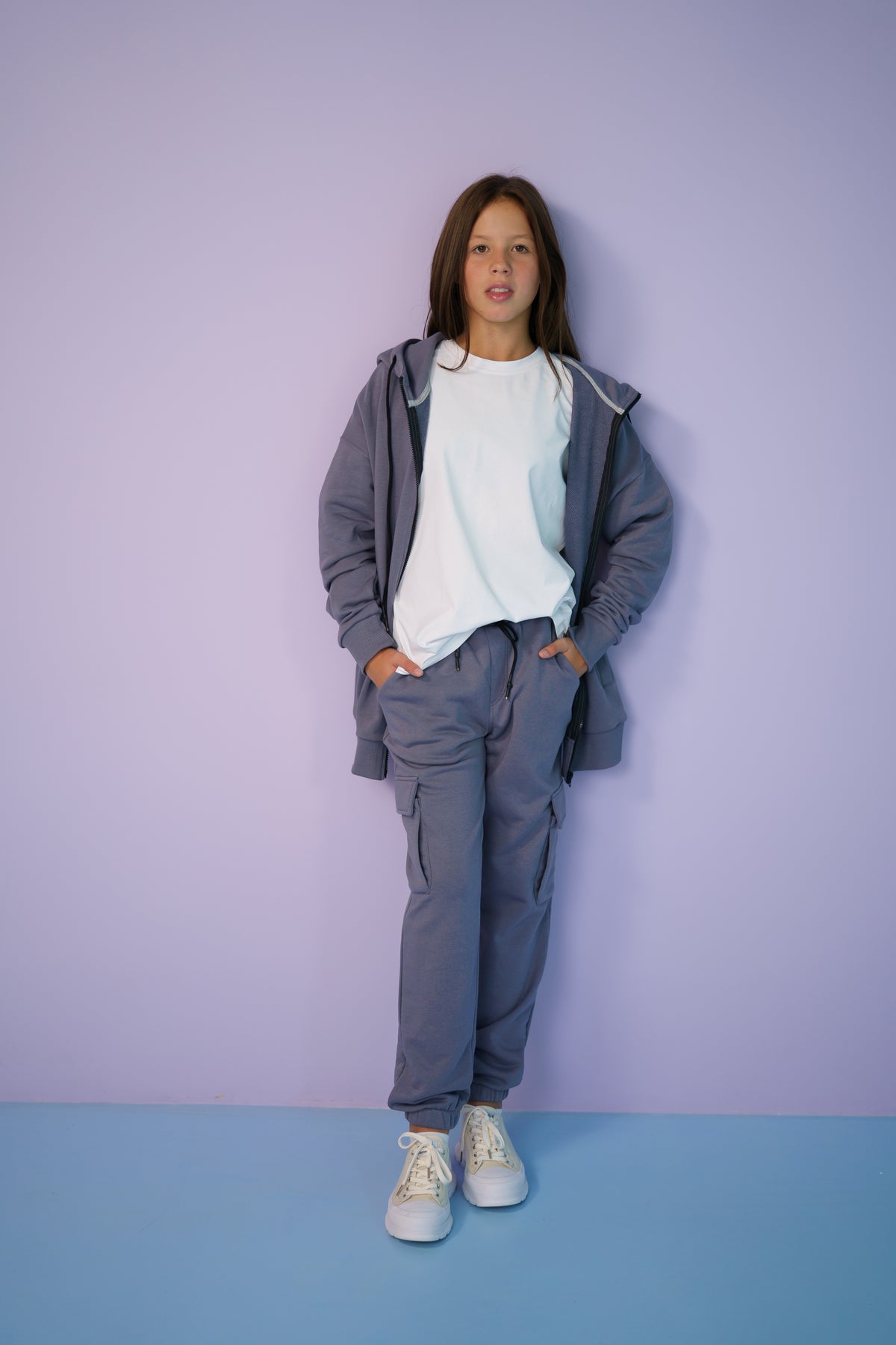 girl wearing a gray tracksuit and a white t-shirt