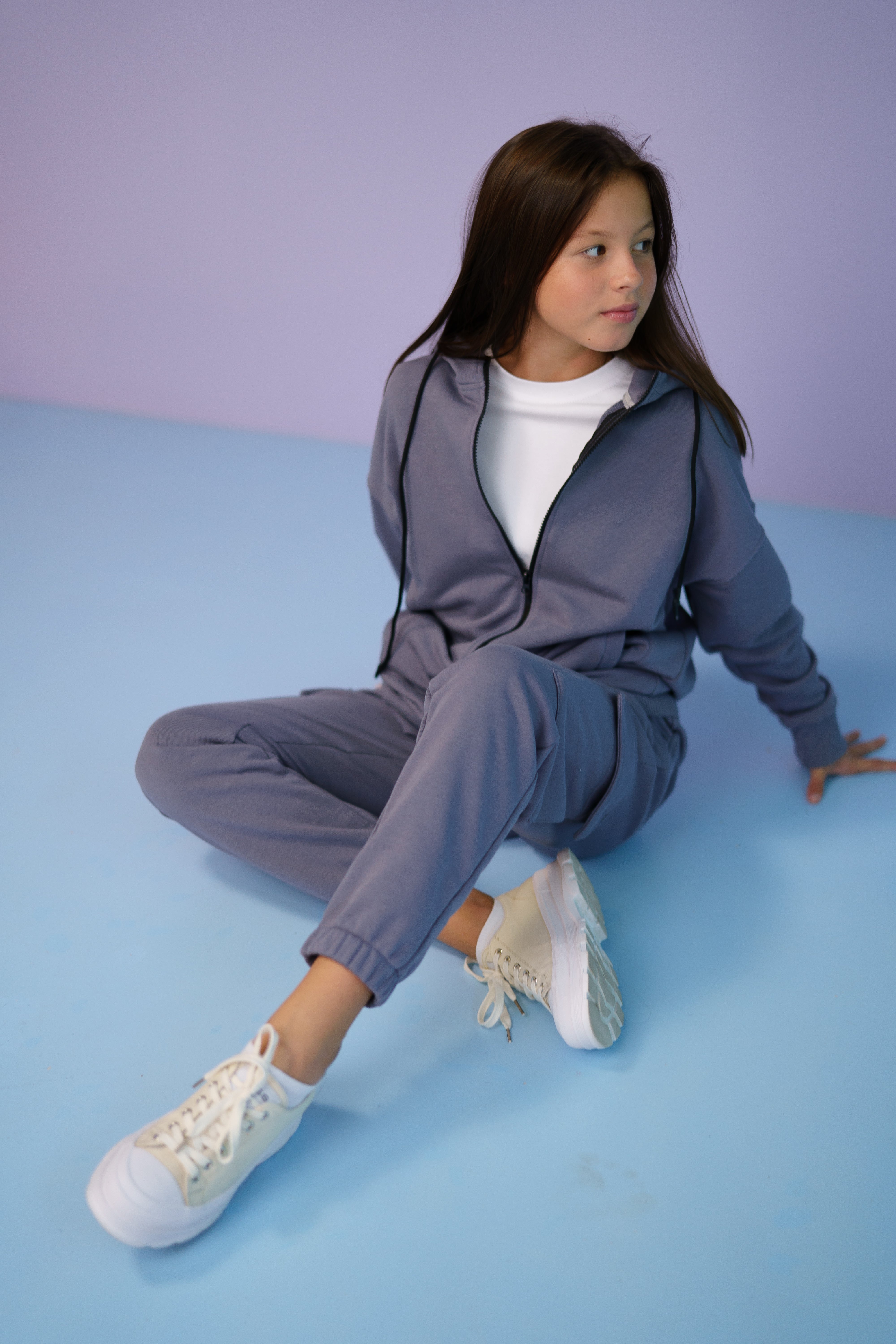 girl in a gray tracksuit by Lemoni sitting on the ground